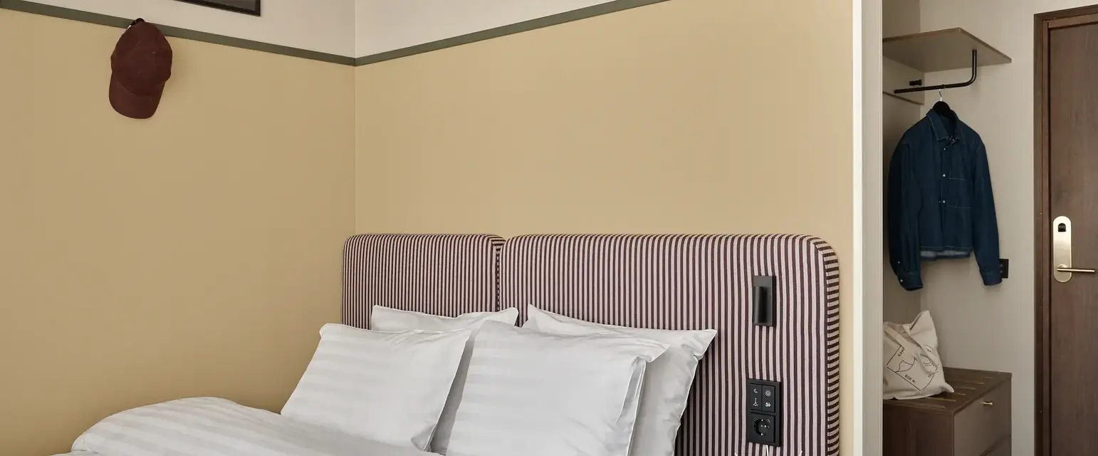 a bed with a striped headboard and a small table