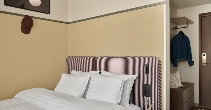 a bed with a striped headboard and a small table