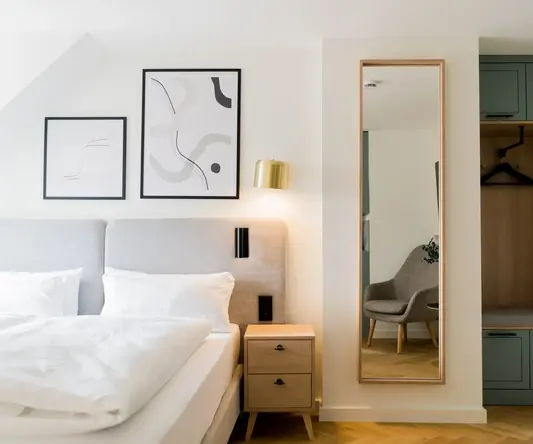 a mirror next to a bed