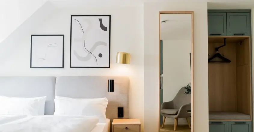 a mirror next to a bed