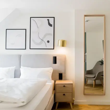 a mirror next to a bed