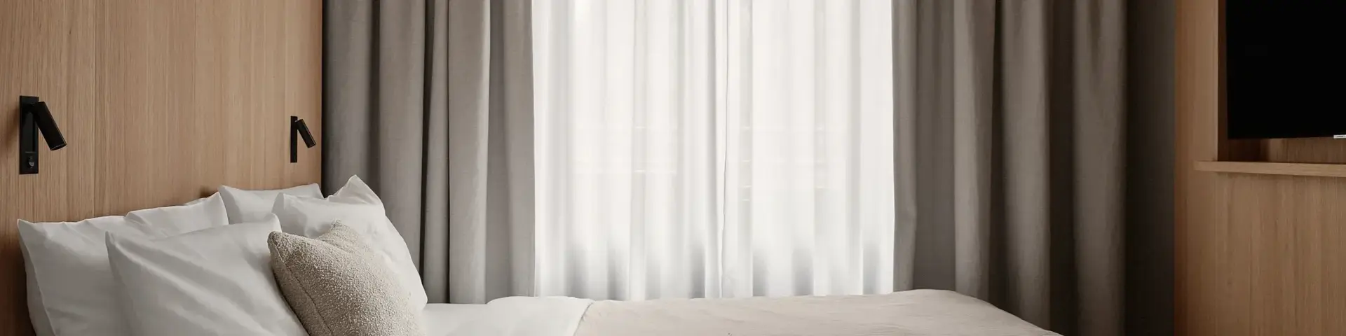 a bed with a pillow and a table in a room with curtains