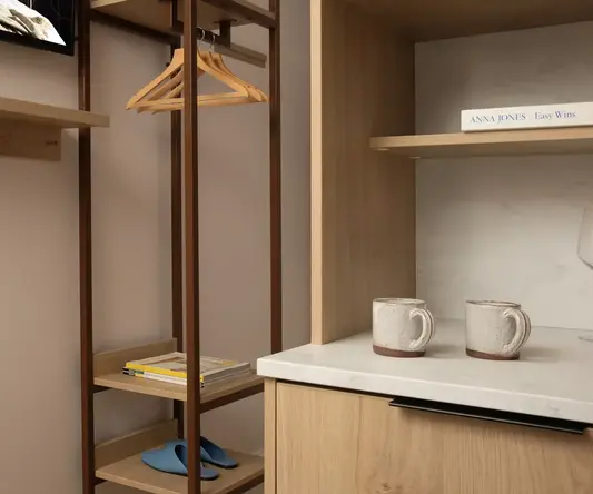 a shelf with a swinger and coffee cups in a room