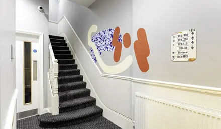 a staircase with a wall mural on the wall