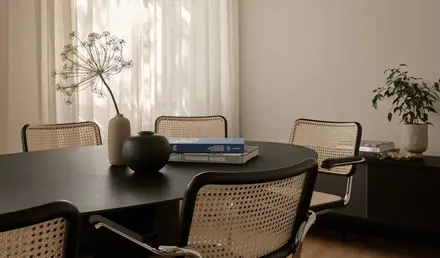 a table with chairs and a vase on it