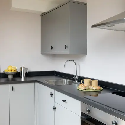a kitchen with grey cabinets and white walls