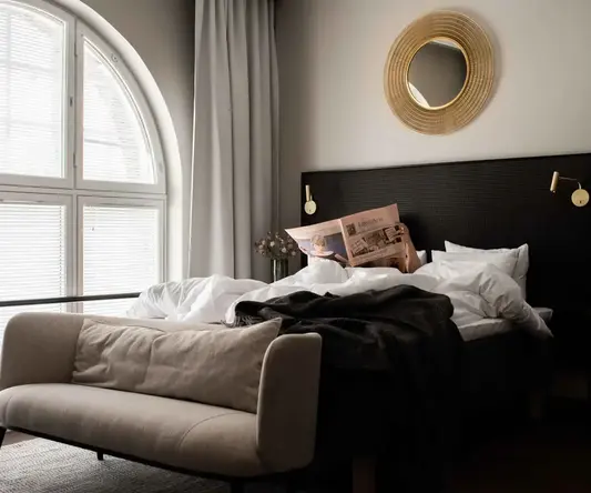 a bed with a couch and a newspaper on it
