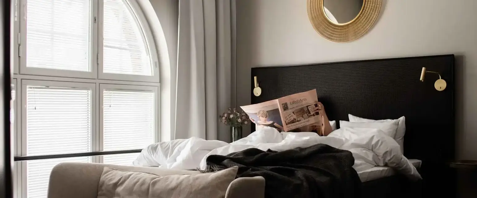 a bed with a couch and a newspaper on it