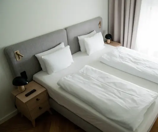 a bed with white sheets and pillows