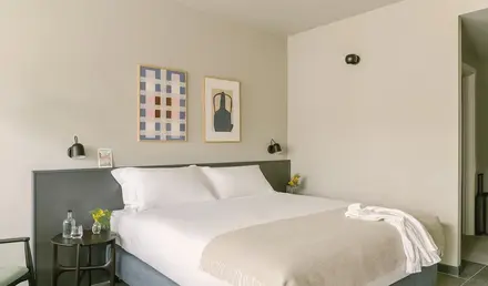 a bed with white sheets and pillows