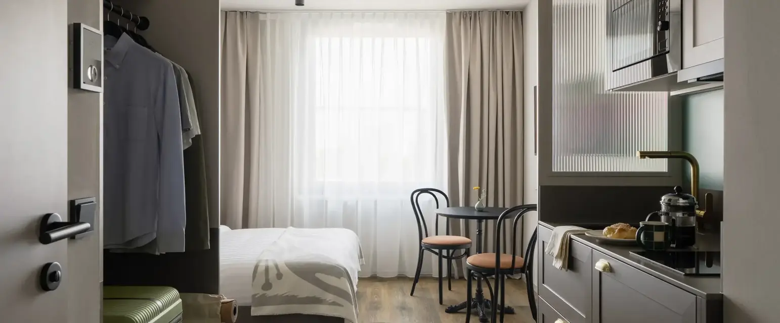 a room with a bed and a table and chairs