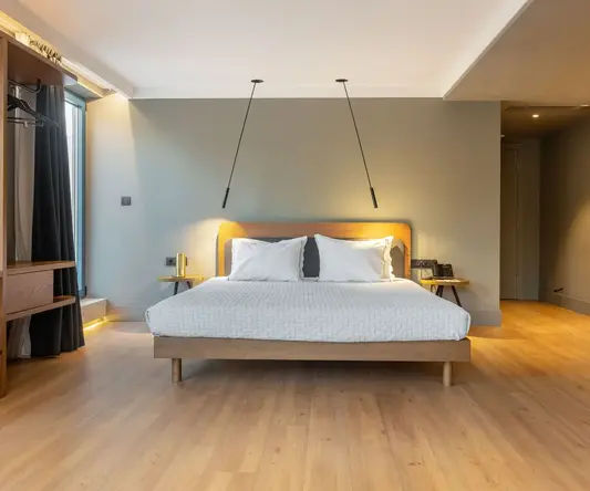 a bed with white pillows and wood floor