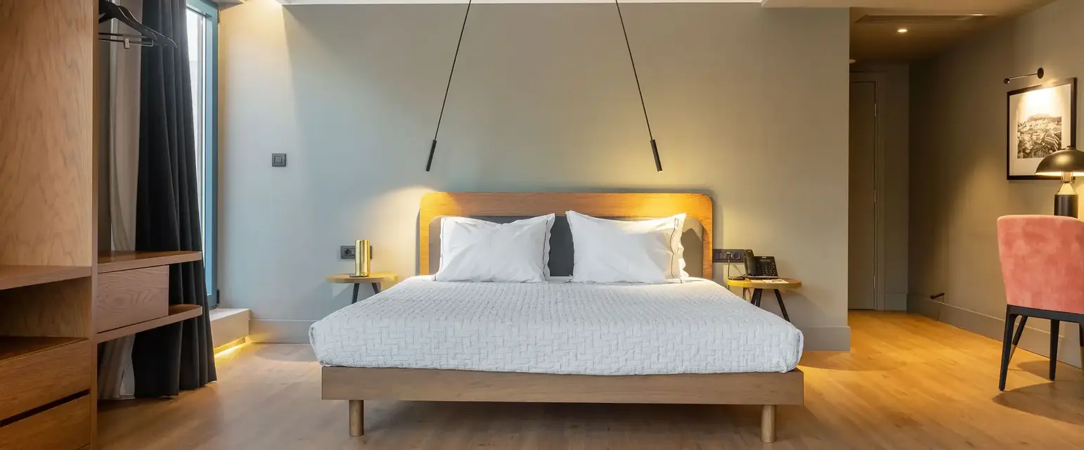 a bed with white pillows and wood floor