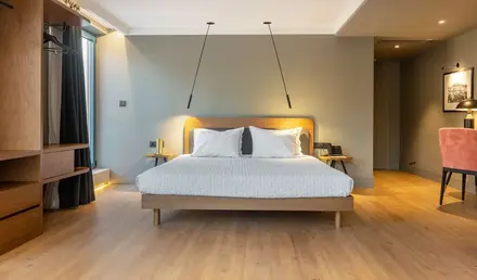 a bed with white pillows and wood floor