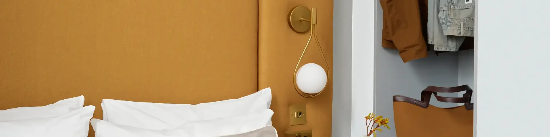 a bed with a headboard and a table with clothes