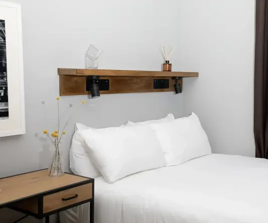 a bed with white sheets and pillows