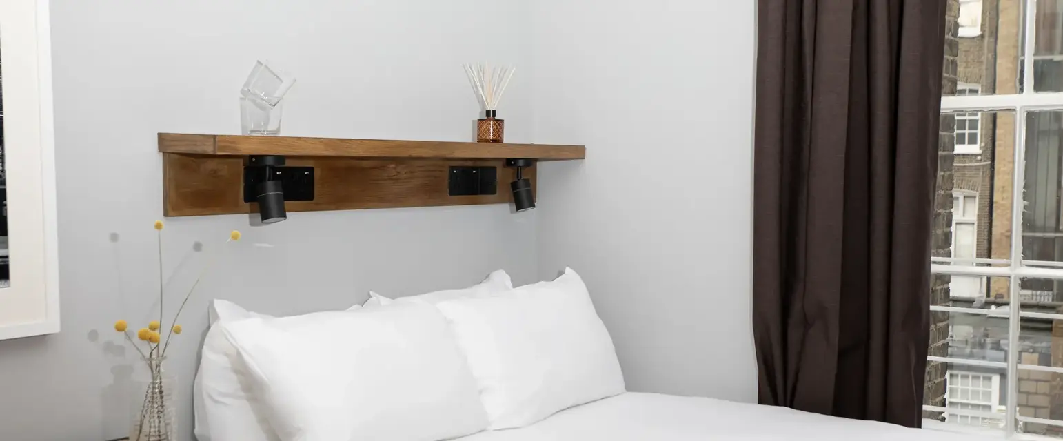 a bed with white sheets and pillows