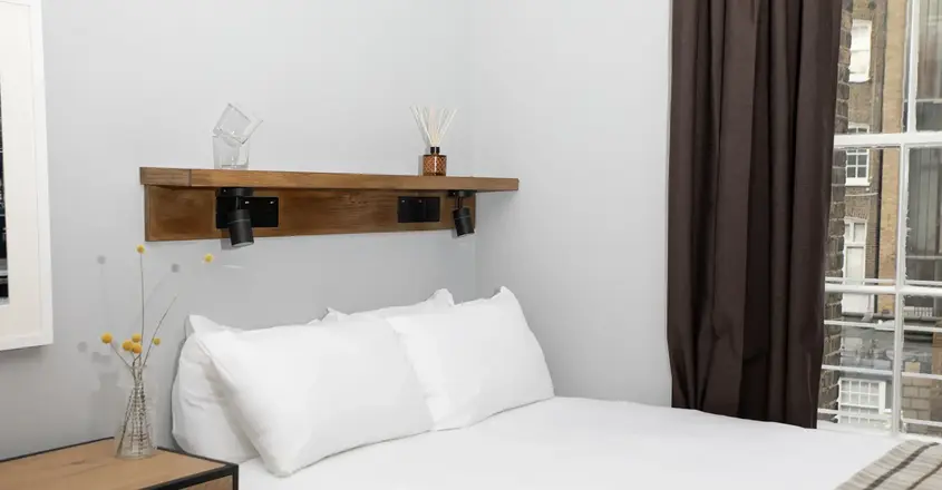 a bed with white sheets and pillows