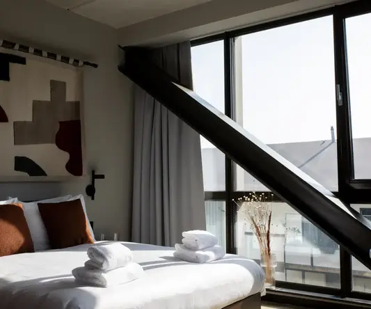 a bed with towels stacked on top of it