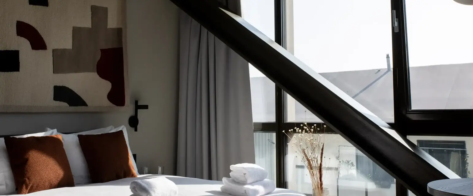 a bed with towels stacked on top of it