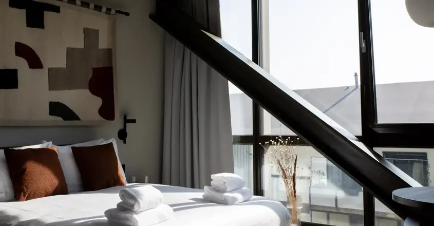 a bed with towels stacked on top of it