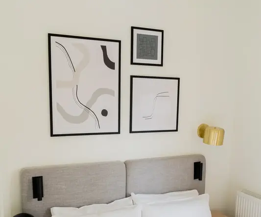 a bed with pillows and a lamp on the side