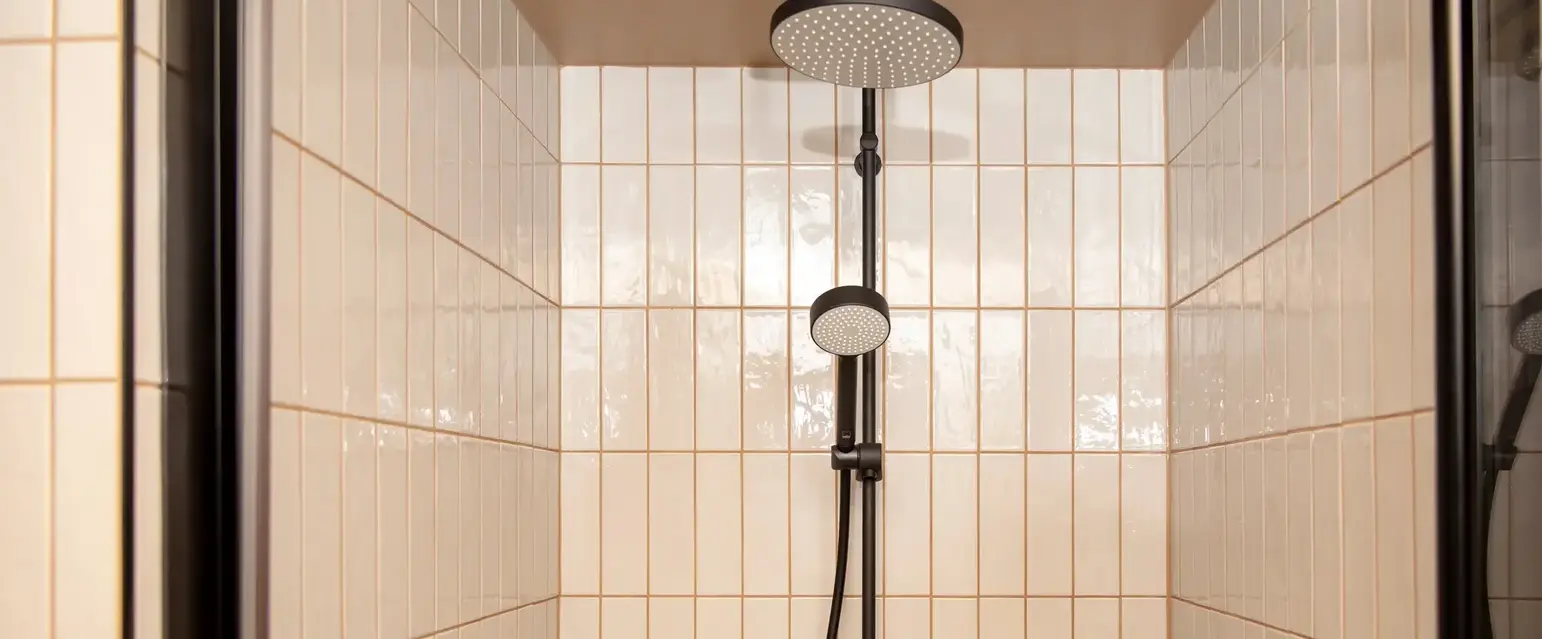 a shower with a shower head and a hose