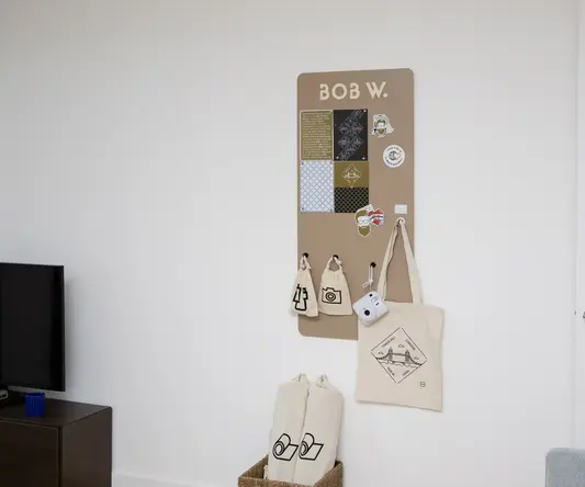 a board with a sign and bags on the wall