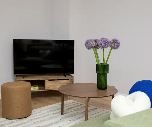 a vase of purple flowers on a table in a living room