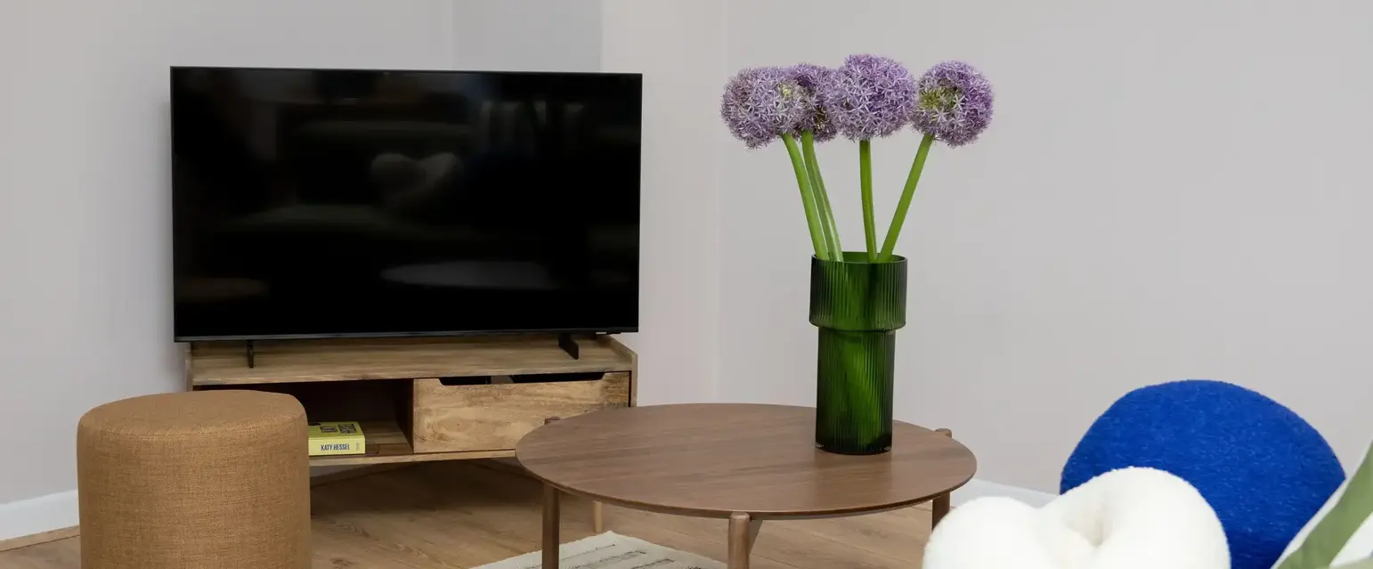 a vase of purple flowers on a table in a living room