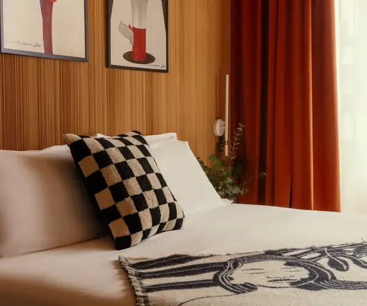 a bed with a checkered blanket and a pillow