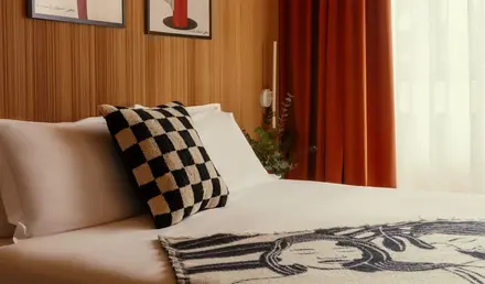 a bed with a checkered blanket and a pillow
