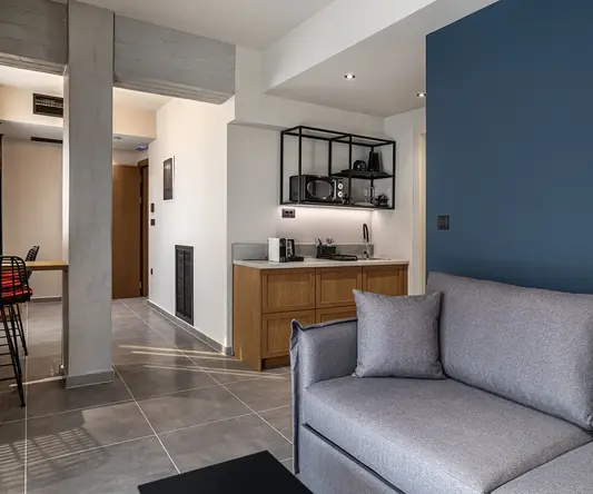 a living room with a couch and a kitchen