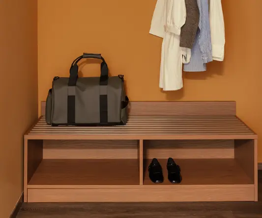 a bag and clothes on a rack