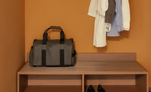 a bag and clothes on a rack