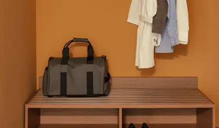 a bag and clothes on a rack