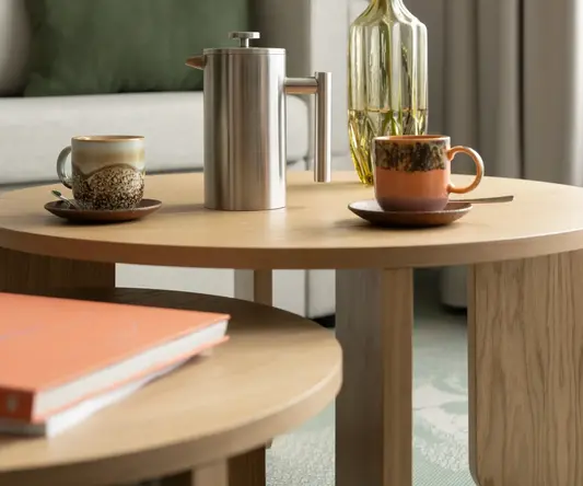 a coffee table with a vase of flowers and cups on it