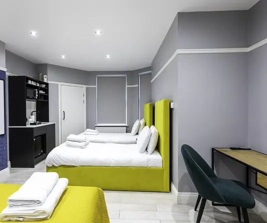 a room with two beds and a desk