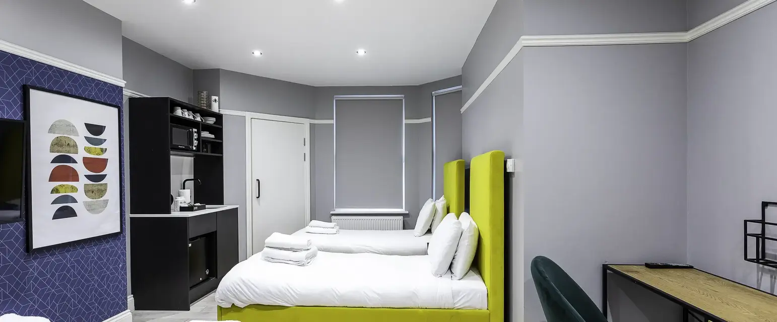 a room with two beds and a desk