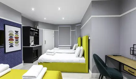 a room with two beds and a desk