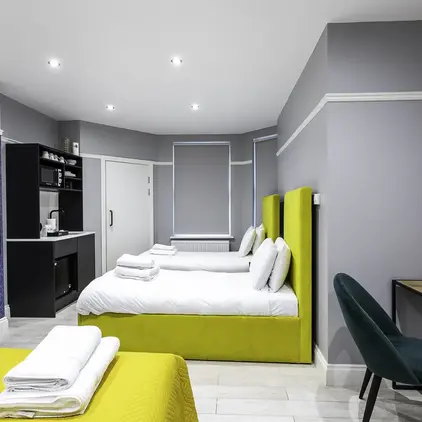 a room with two beds and a desk