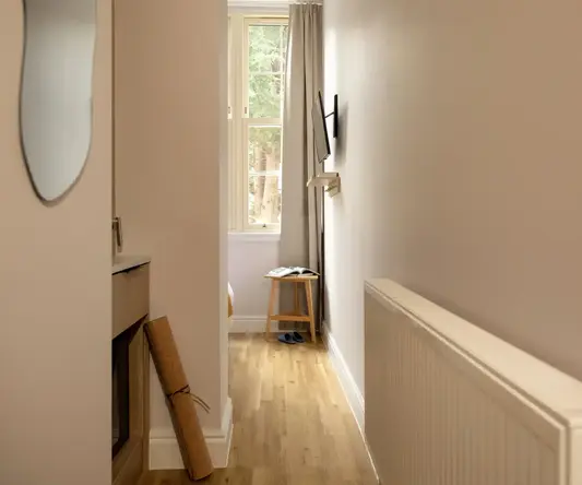 a hallway with a window and a chair