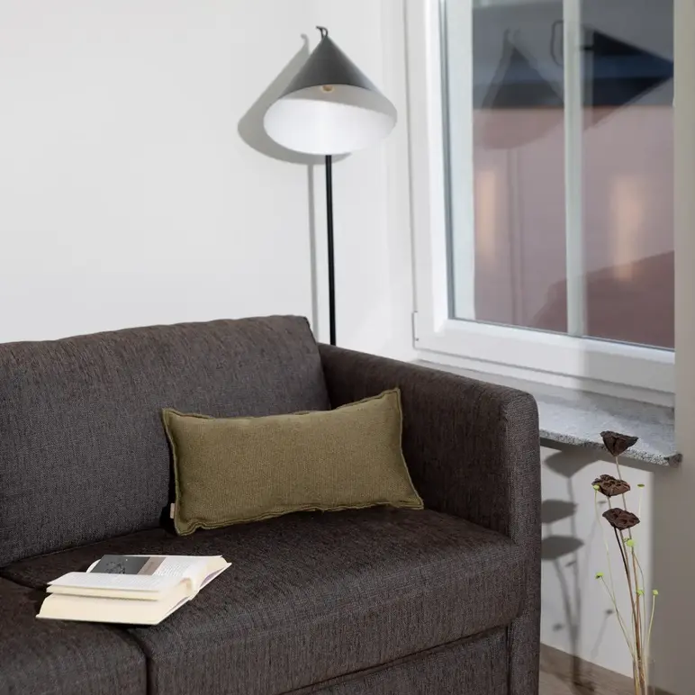 a couch with a book and a lamp in a room