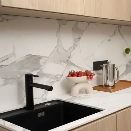 a kitchen counter with a sink and a bowl of tomatoes
