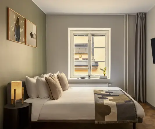 a bed with pillows and a tv in a room
