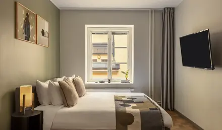 a bed with pillows and a tv in a room
