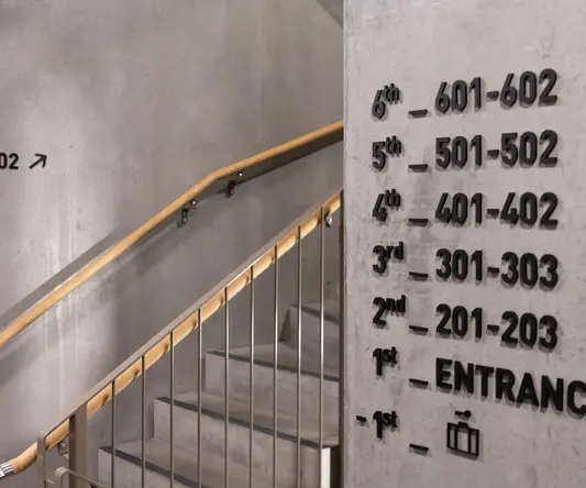 a sign on a wall with stairs