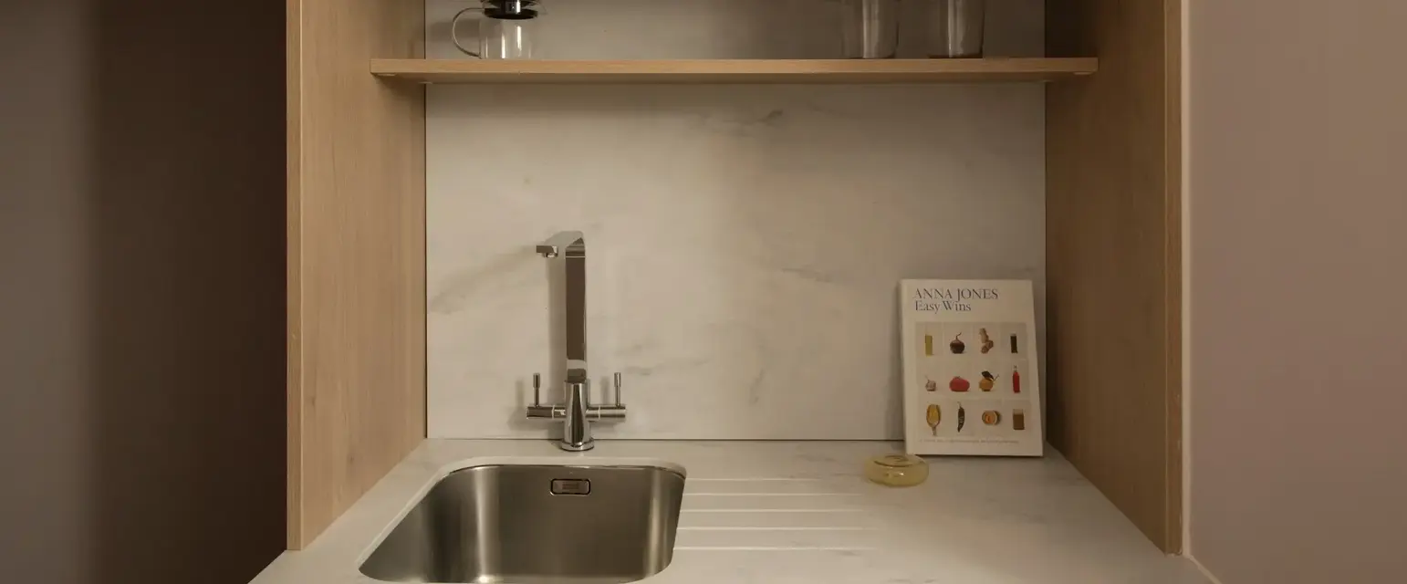 a kitchen with a microwave and a book on the shelf