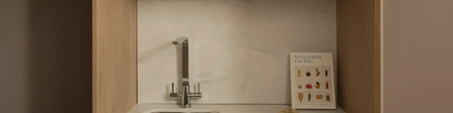a kitchen with a microwave and a book on the shelf