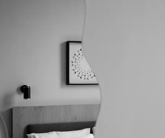 a bed with pillows and a mirror